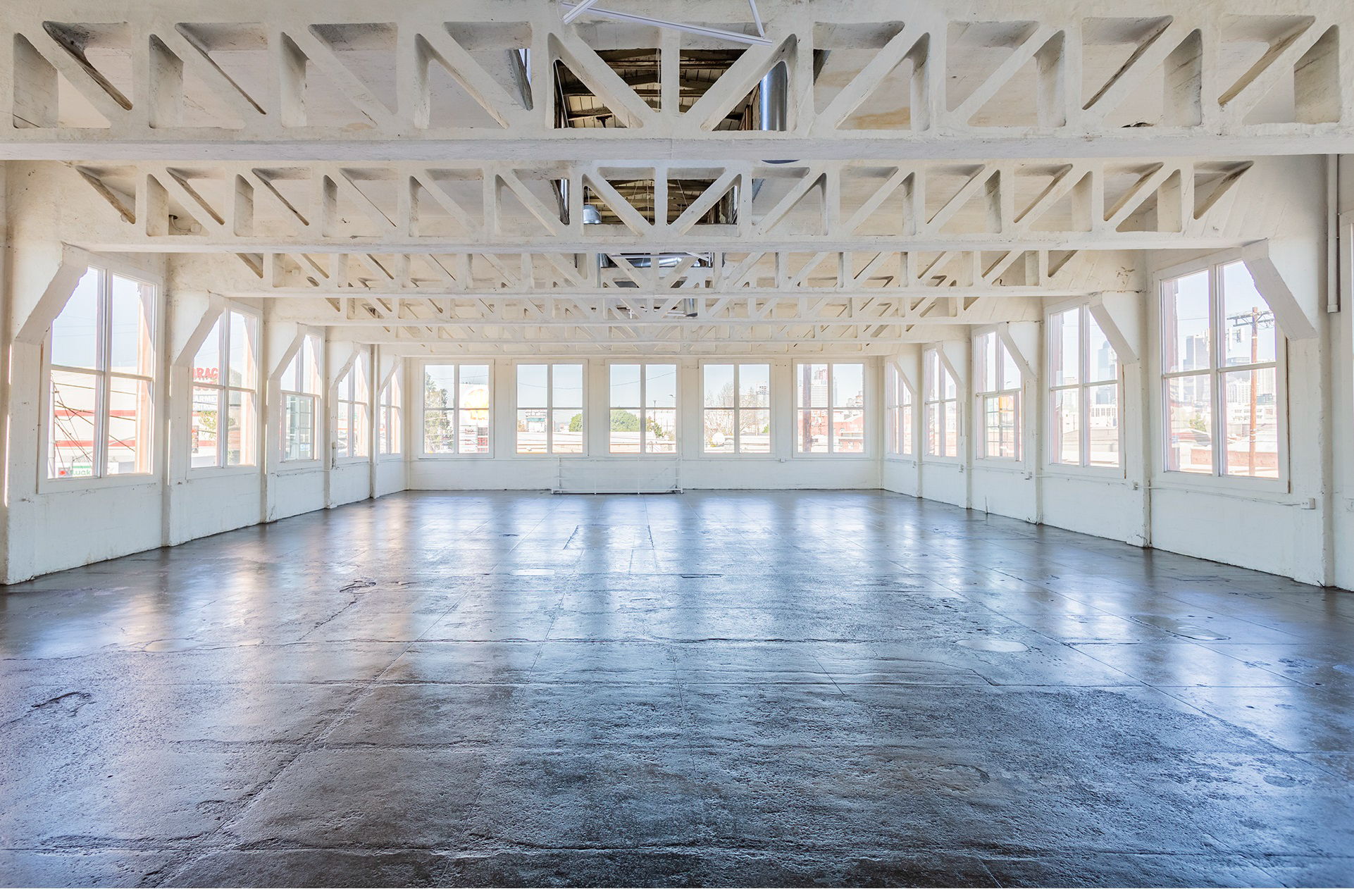 empty warehouse with concrete beams surrounded by windows